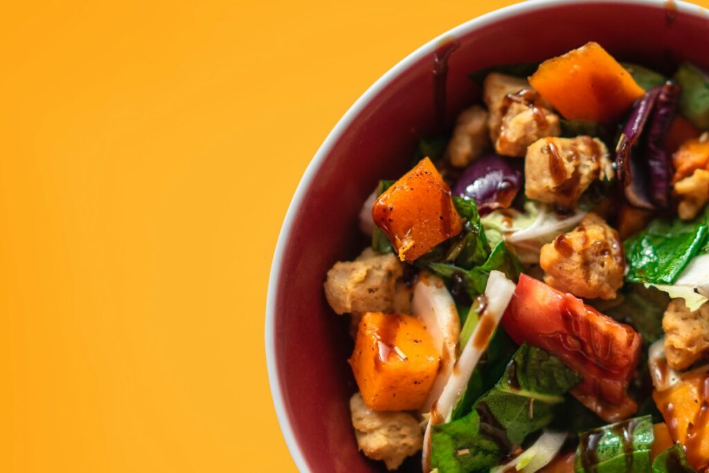 Stir-fried chicken and vegetables in a red bowl