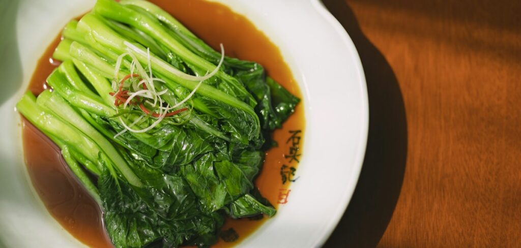 Steamed Chinese greens on a white plate